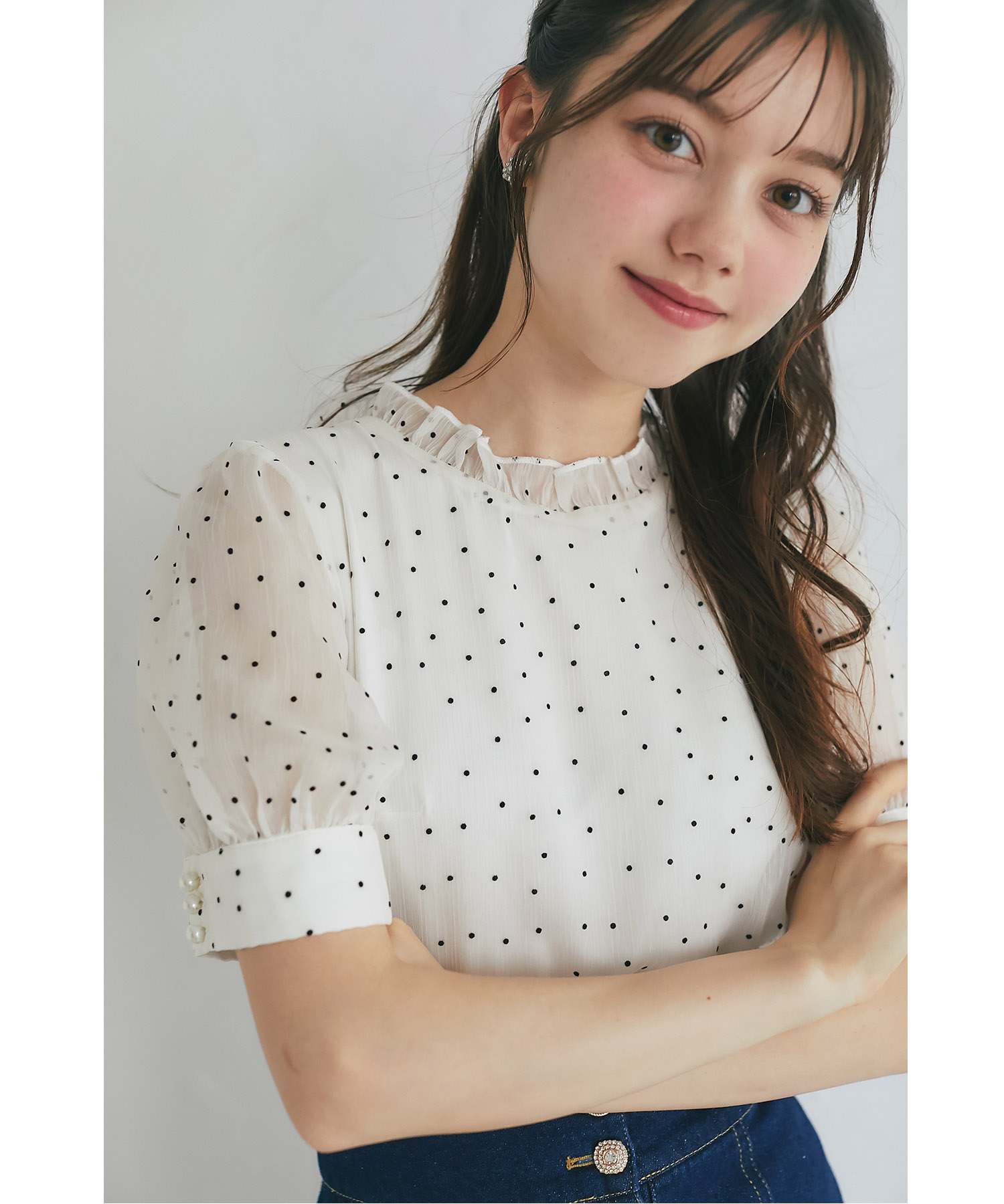 シアーな表情が今っぽいプチフリルネックパール釦フロッキードットブラウス