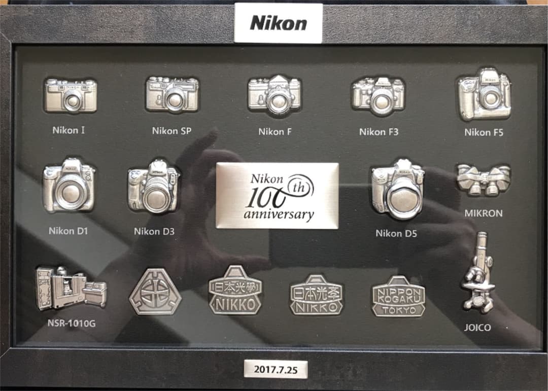 Nikon100周年記念カメラモデルバッジ - メルカリ